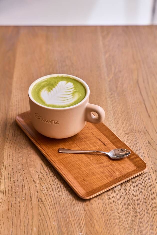 A beautifully crafted matcha latte in a chic cafe setting, highlighting the creamy green beverage topped with a delicate foam.