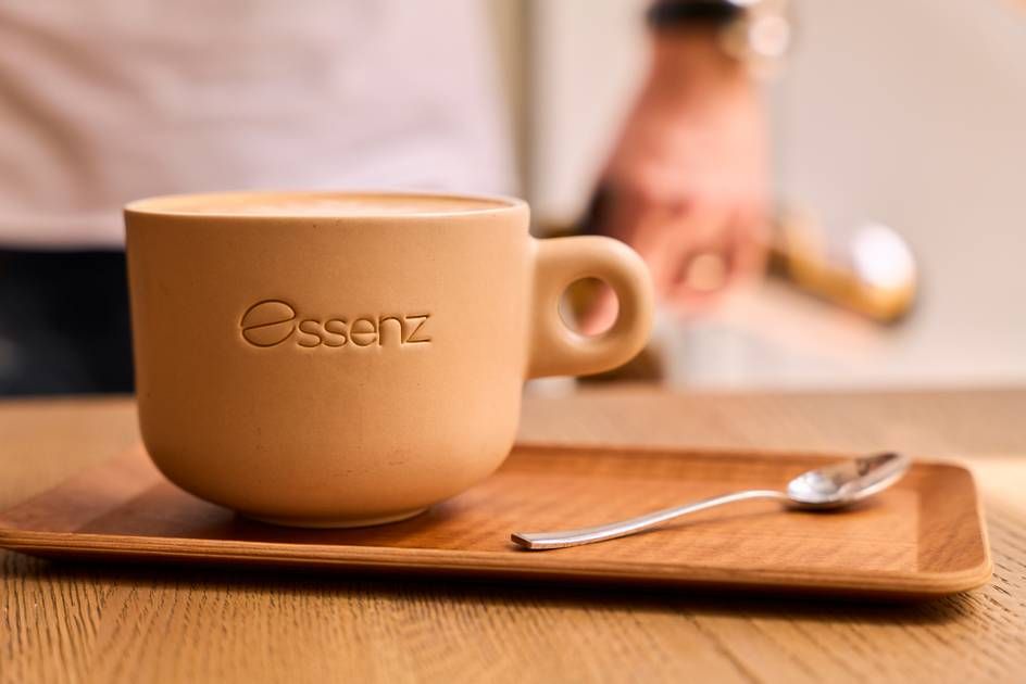 A coffee cup elegantly placed on a wooden tray, showcasing the inviting ambiance of Café Essenz.