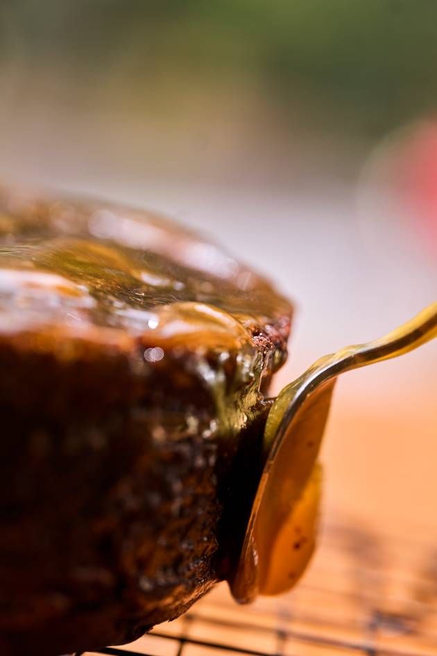 A spoon is used to gather marmalade from a Sacher Cake, perfecting the marmalade layer.