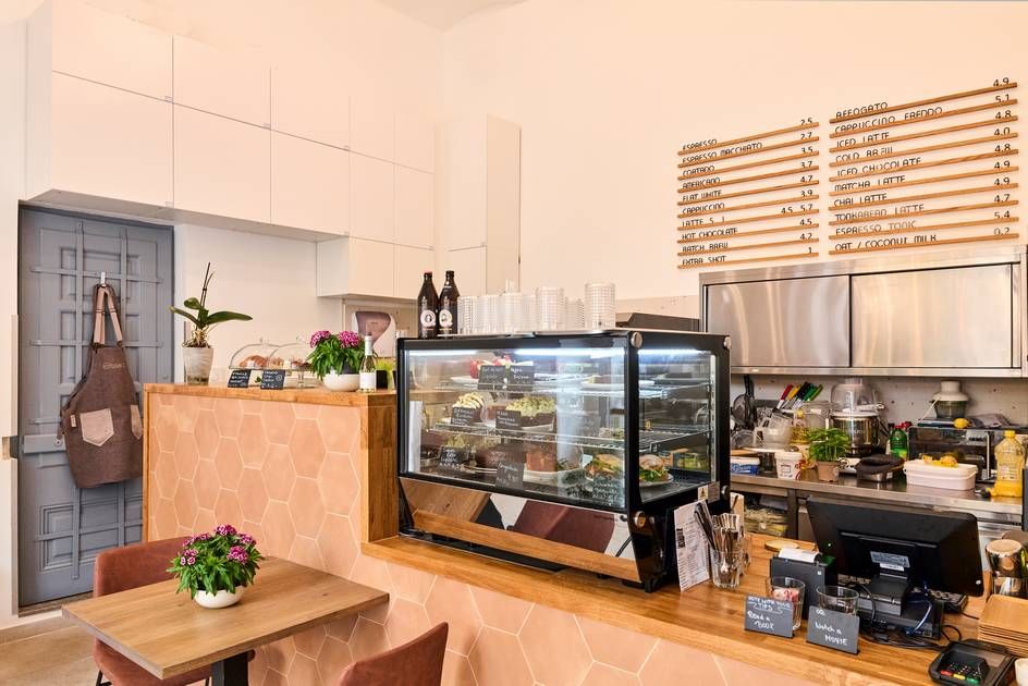 A café service counter with chairs and tables for customers.