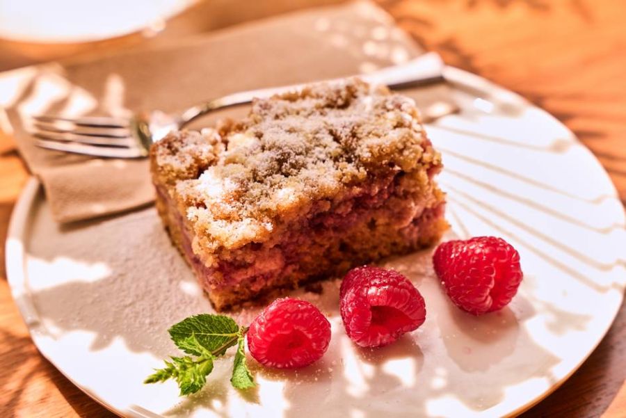 A slice of raspberry crumb cake on a plate.