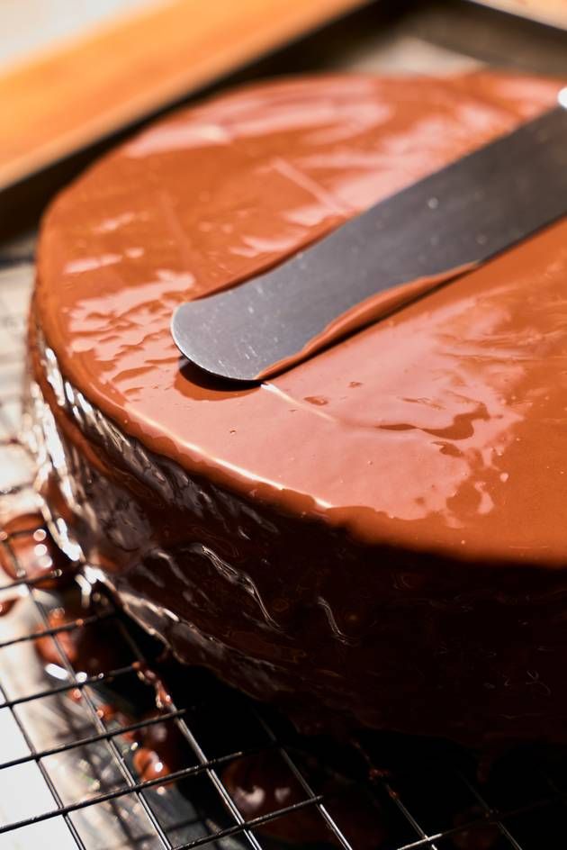 A beautifully covered Sacher chocolate cake with a knife resting on top, emphasizing its luxurious chocolate finish.